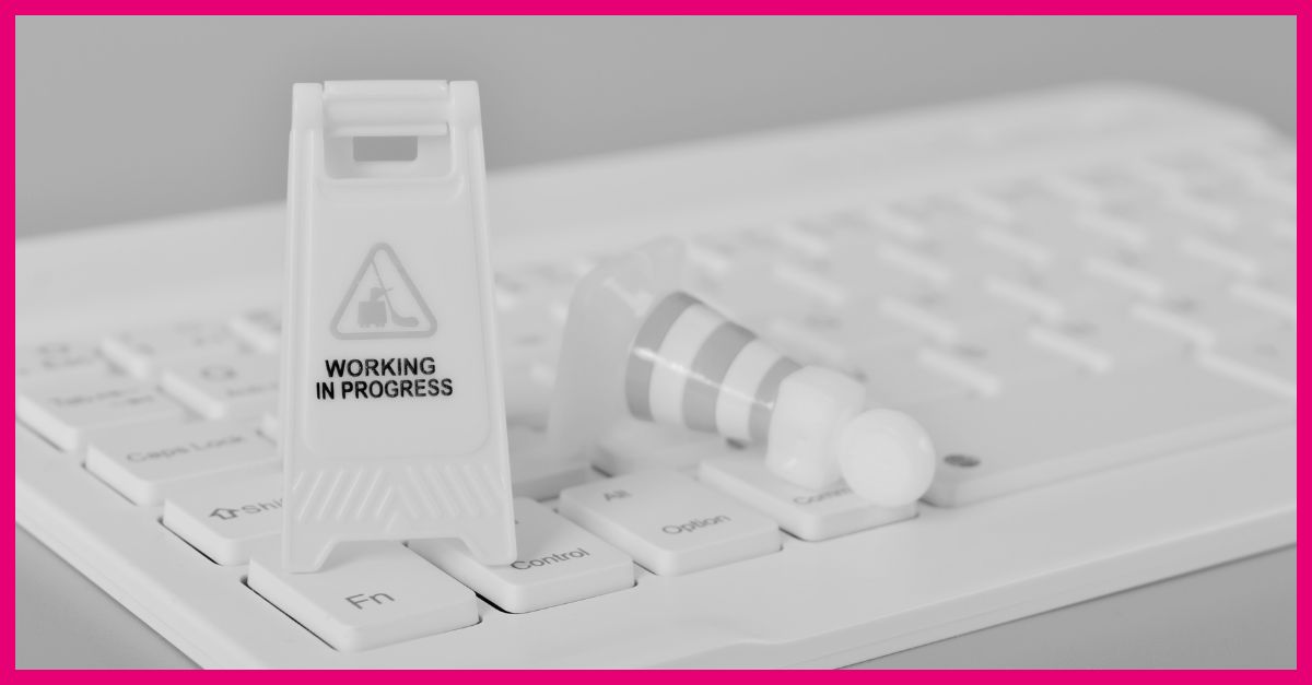 A white keyboard featuring a warning sign, indicating website maintenance